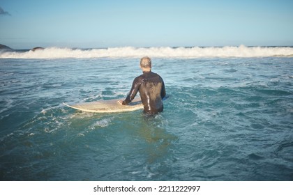 Surfer And Man In Water Watching Wave For High Tide While Holding Surfboard At Sunny USA Beach. Retirement Person Enjoying Surfing Sport Leisure In California Waiting For Ocean Level To Rise.