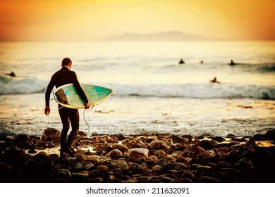 Surfer On The Beach At Sunset