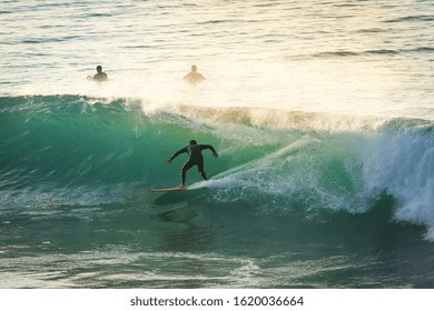 Surfer on Ocean Wave Getting Barreled at Sunset
