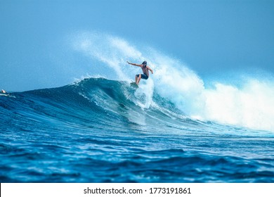 Surfer on perfect blue aquamarine wave, empty line up, perfect for surfing, clean water, Indian Ocean close to Maldivian island Himmafushi
 - Powered by Shutterstock