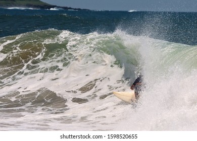 Surfer On Surfboard Riding Inside Wave Tunnel