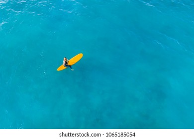 Surfer On A Yellow Board In The Ocean. Aerial Top View