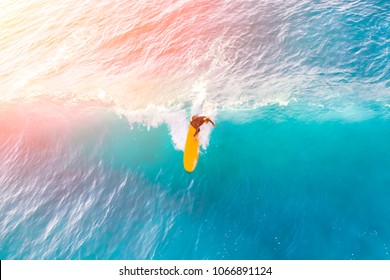 Surfer on a yellow surfboard in the ocean on a sunny day