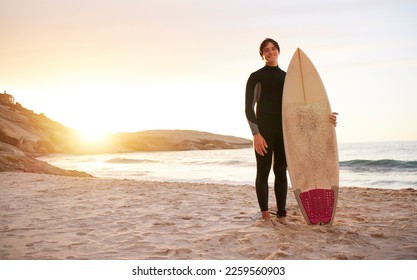 Surfer, portrait and man with surfboard at the sea, beach and ocean in sunset or the morning with mockup space. Young, ready and male in swimsuit on a sunny surf day on the sand, shore and water - Powered by Shutterstock