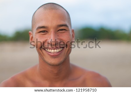 surfer posing on the beach and smiling