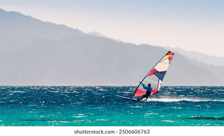 surfer rides in the Red Sea on the background of the rocky coast in Egypt Dahab - Powered by Shutterstock