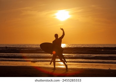 surfer silhouette on the beach at sunset - Powered by Shutterstock