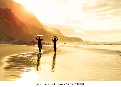 Surfer Silhouettes on the beach at sunset time.
Surfer friends carrying their surfboards on sunset time. Defocused picture. - Powered by Shutterstock