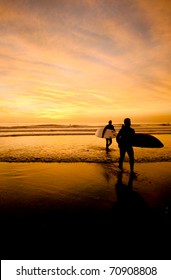 Surfer Silhouettes At Sunset