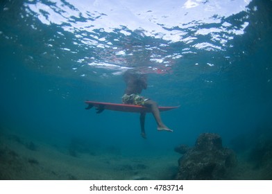 surfer sitting on his surfboard with reef