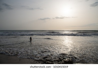 Surfer Standing In The Sun Waiting To Go Out.