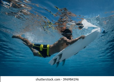 Surfer with surf board dive underwater with fun under big ocean wave