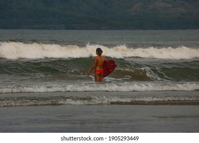 Surfer In Tamarindo Beach Of Costa Rica Trying To Learn Surf