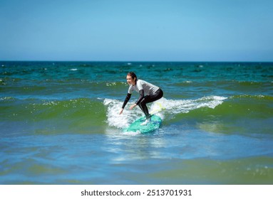 Surfer. Teenage girl learning to surf on foam in the ocean. First surfing lesson. Amateur surfer. Surfing training. Photo for surfing school advertising on social media. - Powered by Shutterstock