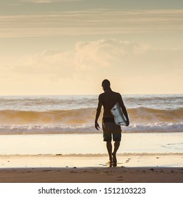 Surfer Walking Into The Waves