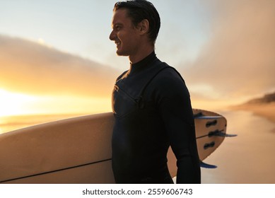 A surfer in a wetsuit holding a surfboard while standing on the beach at sunset, exuding determination and relaxation. - Powered by Shutterstock