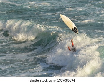 Surfer Wipeout With Waves And Spray Background. Aerial View Of Surfer Falling Off Surf Board In Bright Sunshine