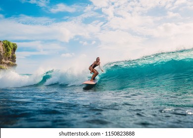 Surfer woman on surfboard during surfing. Surfer and ocean wave