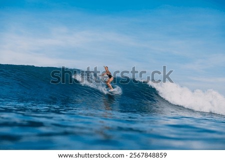 Similar – Image, Stock Photo Young surfer woman in bikini going surfing stands with surfboard on the black sandy beach. Girl walks with longboard. Extreme water sport by the ocean, sea. Healthy Active Lifestyle. Summer Vacation