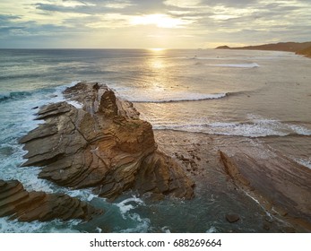 Surfers Do It Surf In Sunset Time In Nicaragua. Surfers Next To Big Rock