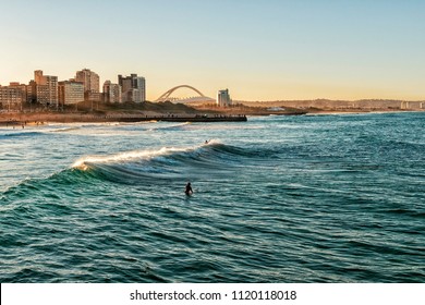 Surfers Enjoying the Waves During Sunset - Shutterstock ID 1120118018
