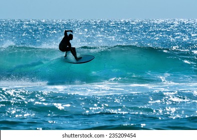 SURFERS PARADISE - OCT 14 2014: Silhouette of Australian surfer surfing on a large wave on Main Beach,  a very popular surfing spot in Surfers Paradise Gold Coast in Queensland, Australia.