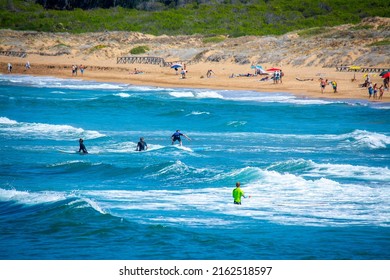 Surfers in Porto Ferro beach. Sardinia, Italy