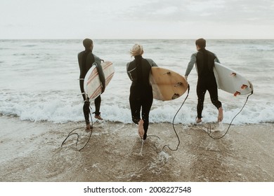 Surfers running towards the sea - Powered by Shutterstock