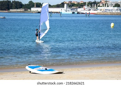 Surfers Surfing With Windsurfing Board In The Sea