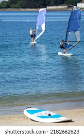 Surfers Surfing With Windsurfing Board In The Sea