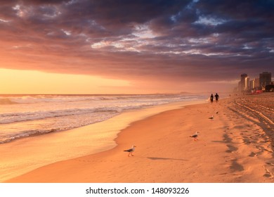 Surfers Walk Along The Beach At Sunrise (gold Coast,qld,australia)