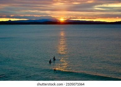 Surfers Watching The Sunset In Noosa Sea