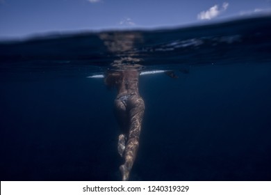 Surfing girl is hanging on a surfboard in the ocean