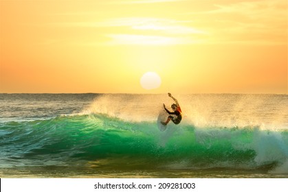Surfing on a Green Wave with Sun Rising in the Background
