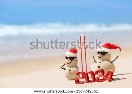 The Surfing Sandmen added a touch of coastal charm to the beach, watching waves with a surfboard and spreading beachside bliss. New years concept, with 3d 2024 numbers