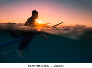 Surfing at Sunrise with underwater view