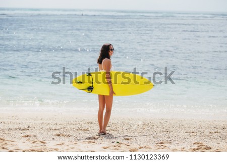 Similar – Young surfer woman with top and bikini holding surfboard