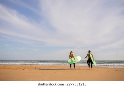 Surfing Together. Young Couple With Surfboards Going Into The Ocean, Rear View Of Sporty Surfers Man And Woman Walking On The Beach And Smiling To Each Other, Waiting For High Waves, Copy Space - Powered by Shutterstock