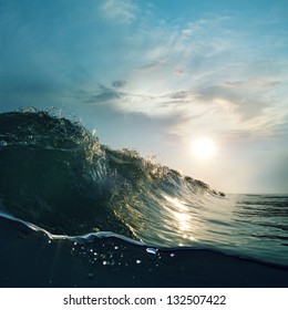 Surfing tropical design template. Green blue colored ocean surfing wave breaking and splashing at sunset time