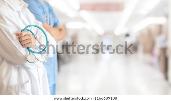Surgeon and\
anesthetist doctor ER team with medical clinic room background for\
emergency nursing care professional teamwork and patient trust in\
hospital\'s hospitality concept\
