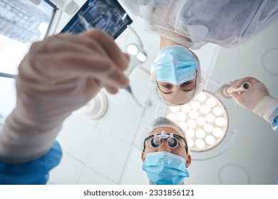 Surgeon dentist with an assistant at workplace in t operating room - Powered by Shutterstock