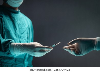 Surgeon doctor holding surgical scalpel and passing surgical equipment to each other in operating room at hospital. Professional surgical team operating surgery patient, healthcare and medical concept - Shutterstock ID 2364709423