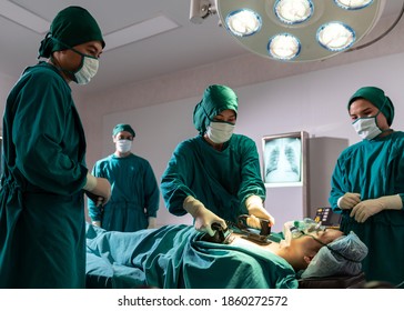 Surgeon doctor and nurse using Defibrillator to patient while patient have problem with Sudden Cardiac Arrest while surgery in Operating Room OR. Medical health care Surgery concept.