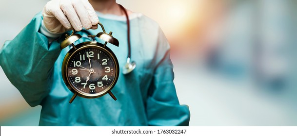 surgeon doctor woman holding alarm clock showing 7 am or pm
