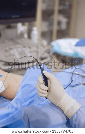 A surgeon holding an catheter equipment for Endovenous Radiofrequency Ablation during vericose veins treatment  Stock foto © 