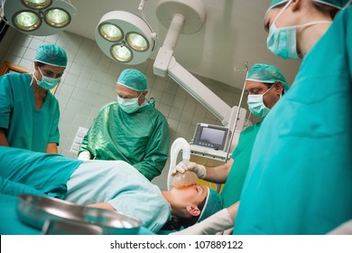 Surgeon holding a mask on the face of a woman in a surgical room - Powered by Shutterstock