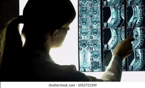 Surgeon looking at patient neck x-ray, pointing image, spine injury treatment - Powered by Shutterstock