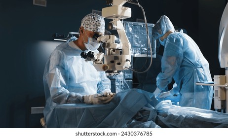 A surgeon looks through a microscope in the operating room. A doctor uses a microscope during eye surgery or diagnosis, cataract treatment and diopter correction. - Powered by Shutterstock