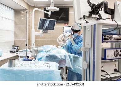 Surgeon In The Operating Room Performing An Operation On A Man Lying On The Operating Table