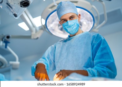 Surgeon in operating room with surgery equipment. Medical team performing operation.